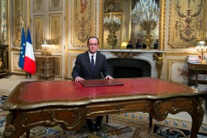 French President Francois Hollande delivers his New Year's wishes during a pre-recorded address to the nation at the Elysee Palace in Paris on December 31, 2014.  AFP PHOTO / POOL / IAN LANGSDON
